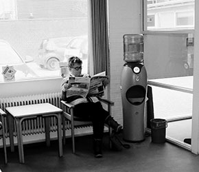 Ældre kvinde venter på sin fysioterapeutiskebehandling i receptionen hos Fysioterapeuterne Kongensgade.
